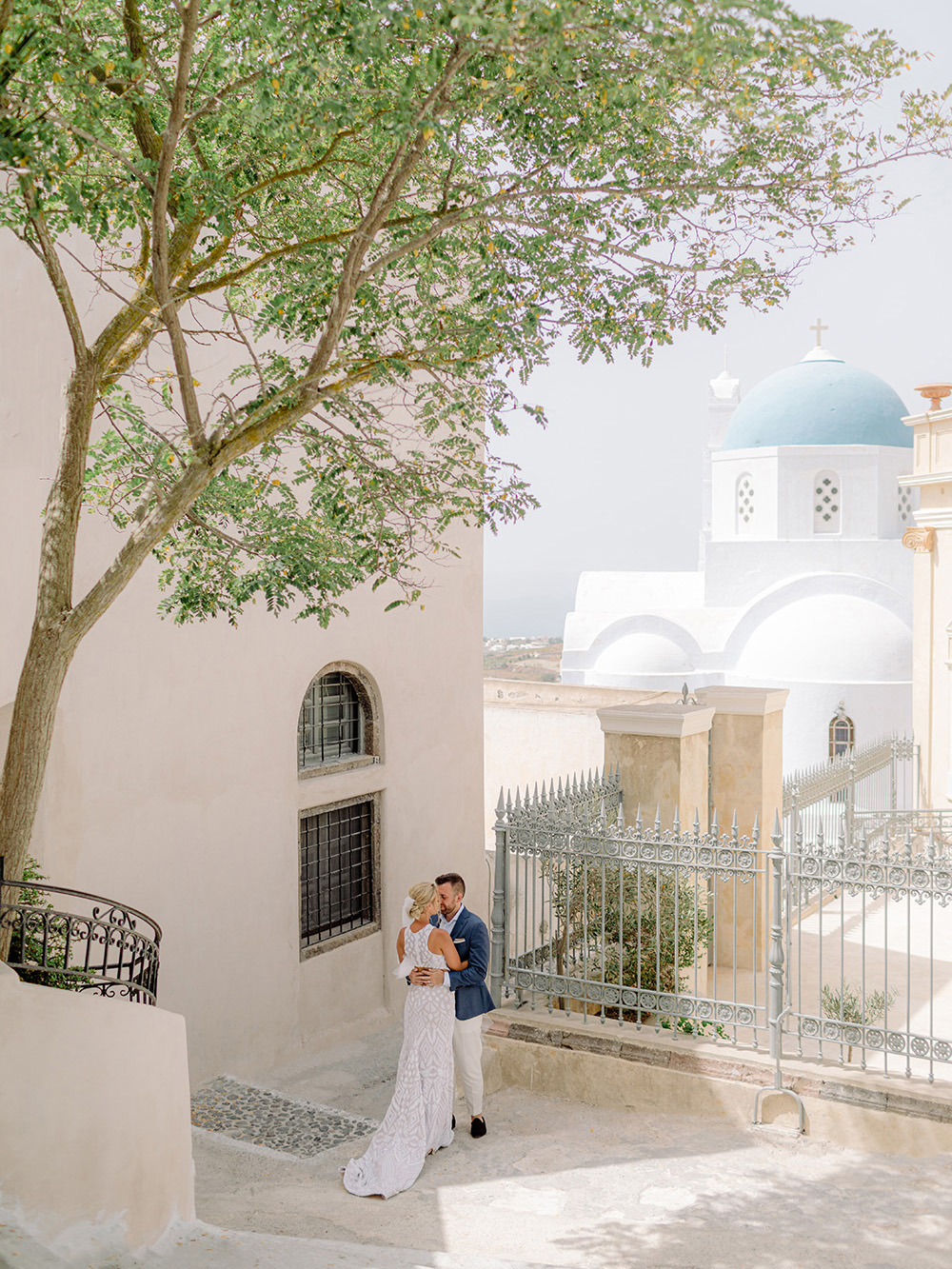 santorini wedding couple hugging blue dome in the background
